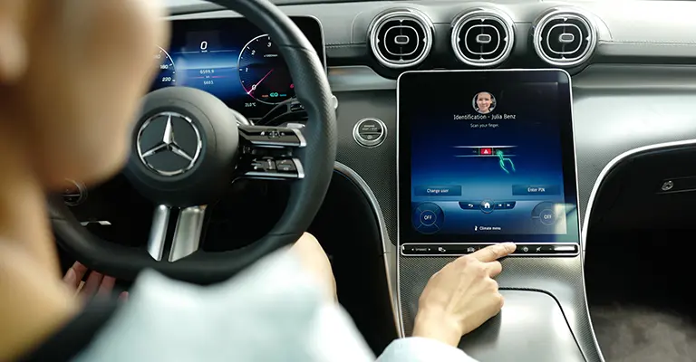 Eine Frau im Mercedes nutzt das fahrzeuginterne Display