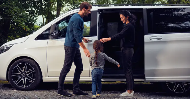 Mama und Papa öffnen ihrer Tochter die Tür zum einsteigen in eine Mercedes V-Klasse