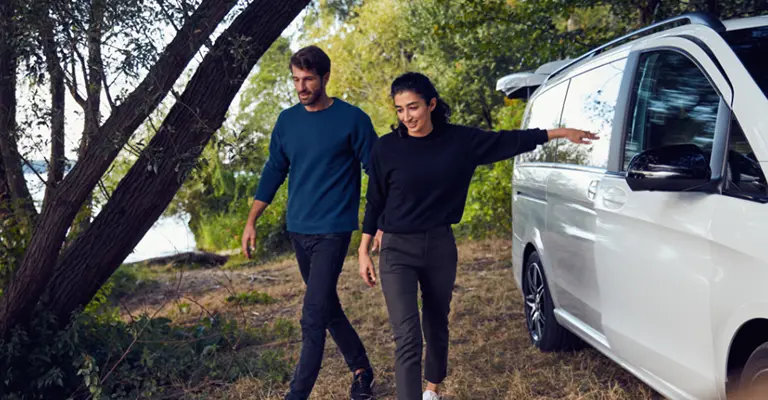 Ein junges Paar auf Reisen mit ihrer Mercedes V-Klasse profitiert von den Reise-Service-Vorteilen der Mercedes Creditcard