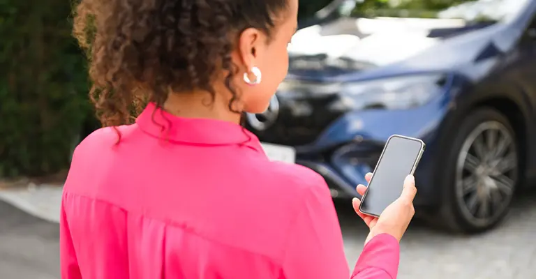 Eine Frau nutzt die Online-Services der Mercedes Credit Card mit dem Smartphone